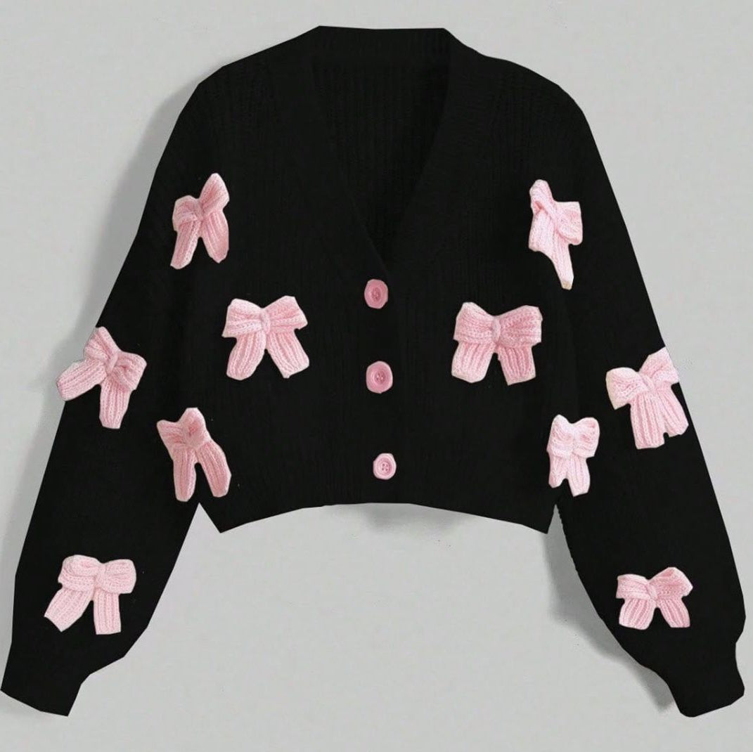 Black sweater with pink bows on a light gray background