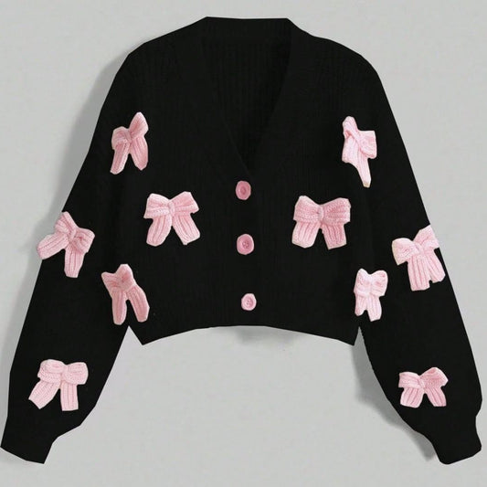 Black sweater with pink bows on a light gray background